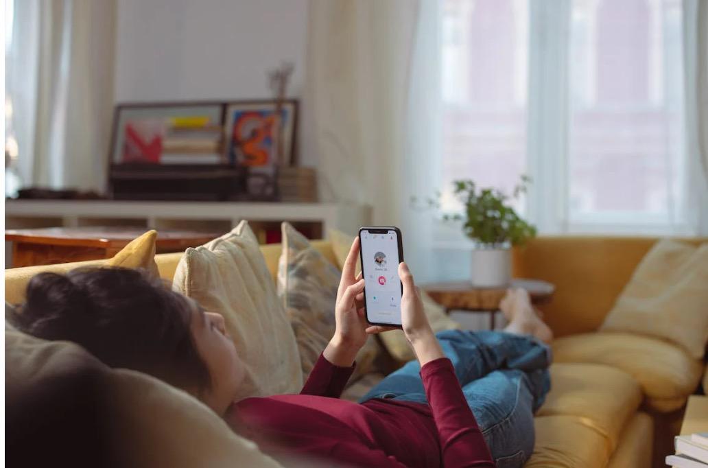 girl-on-couch-using-dating-app-on-phone